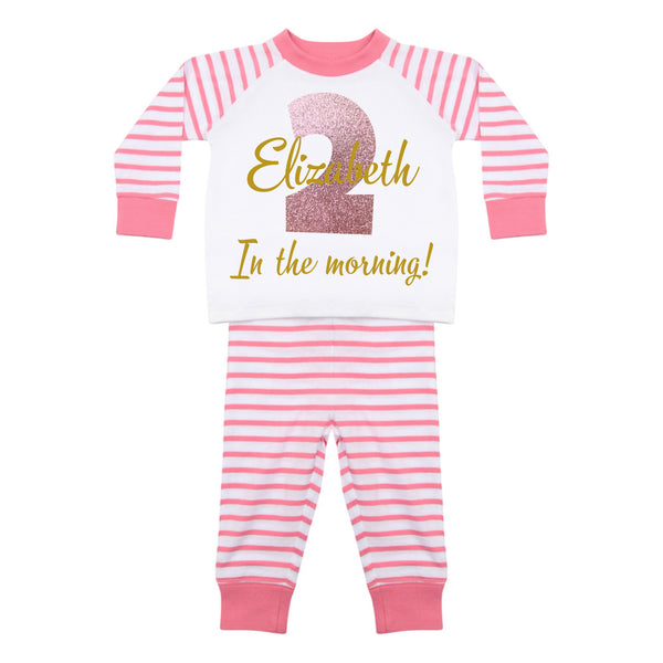 Pink and white striped baby pyjamas that read: Elizabeth 2 in the morning!