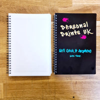 Two A5 notebooks side by side. One displaying a blank cover ready for printing. The other is printed black with a colourful Personal Prints UK logo at the top, below reads "We'll stick it anywhere (even there)" in a neon green colour.